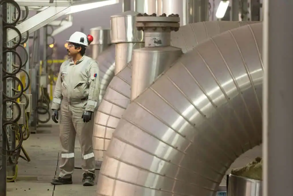 Oil & gas industry worker inspecting equipment in Dubai factory.