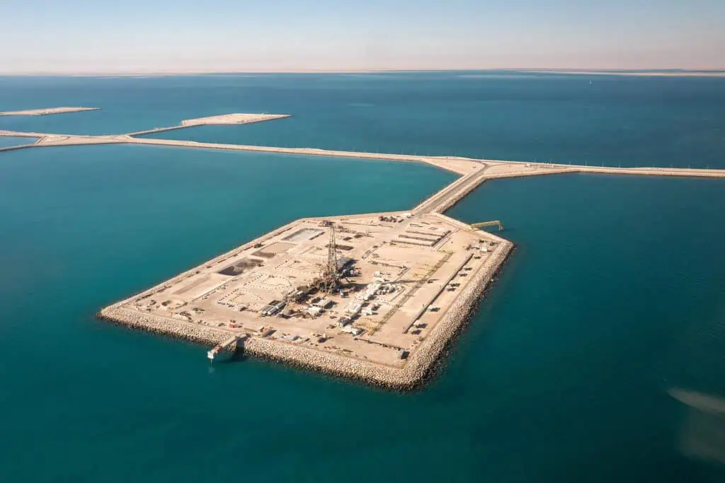 Aerial view of Saudi's oil and gas port with breakwaters and construction site.