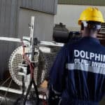 Oil and gas worker in Dubai wearing safety gear and inspecting equipment.