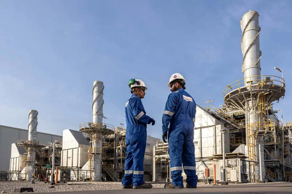 Oil and gas workers inspecting equipment at Dubai industrial site.