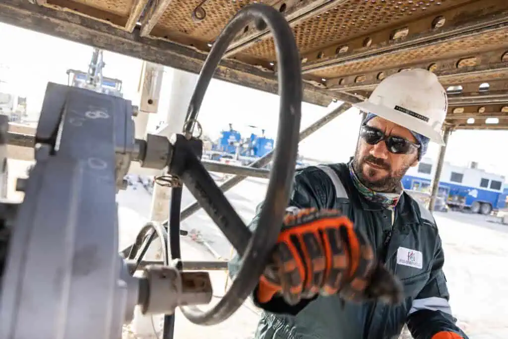 Oil and gas worker operating equipment in Oman industrial site.