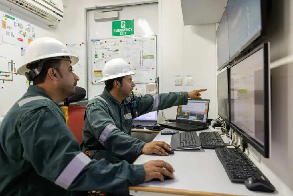 Oil and gas engineers monitoring systems in control room Oman.