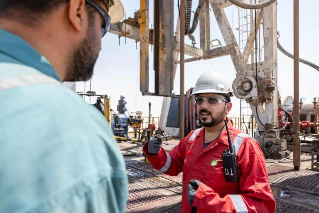 Oil and gas industry professionals discussing at Dubai oil rig site.