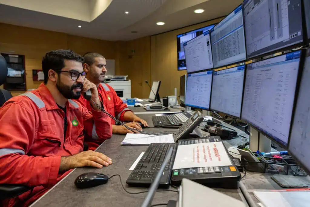 Oil and gas professionals working at multiple monitors in Dubai.