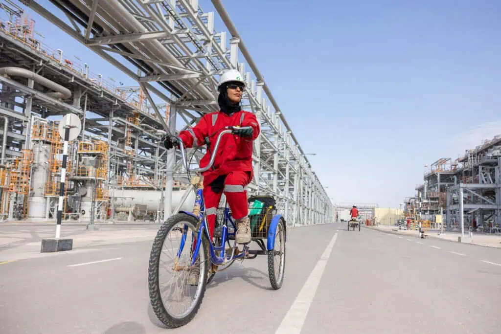 Engineer riding a bicycle at an oil and gas industrial site in Dubai.