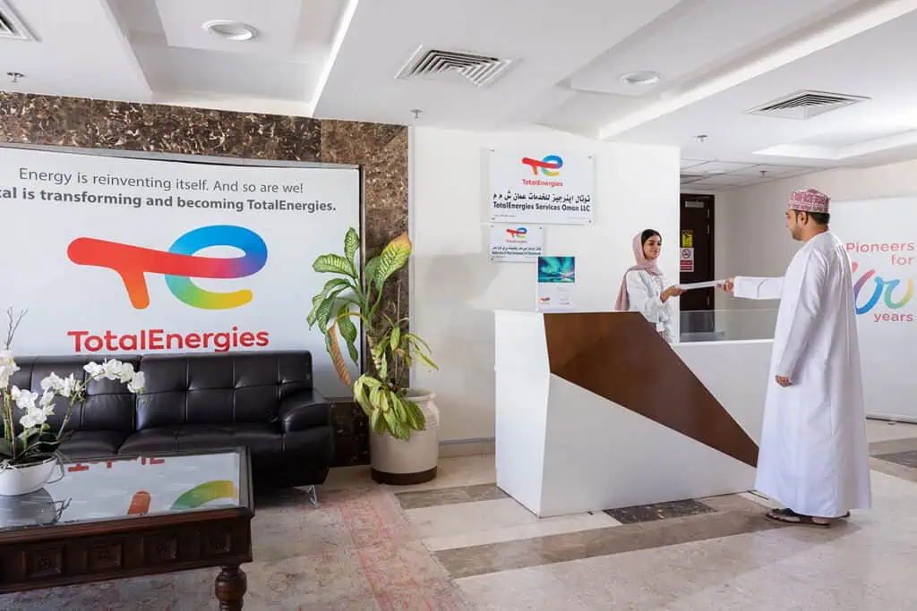 Businessmen shaking hands at corporate reception in Dubai office.