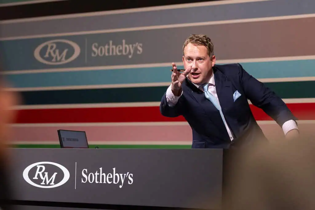 Professional auctioneer at Sotheby's event in Dubai.