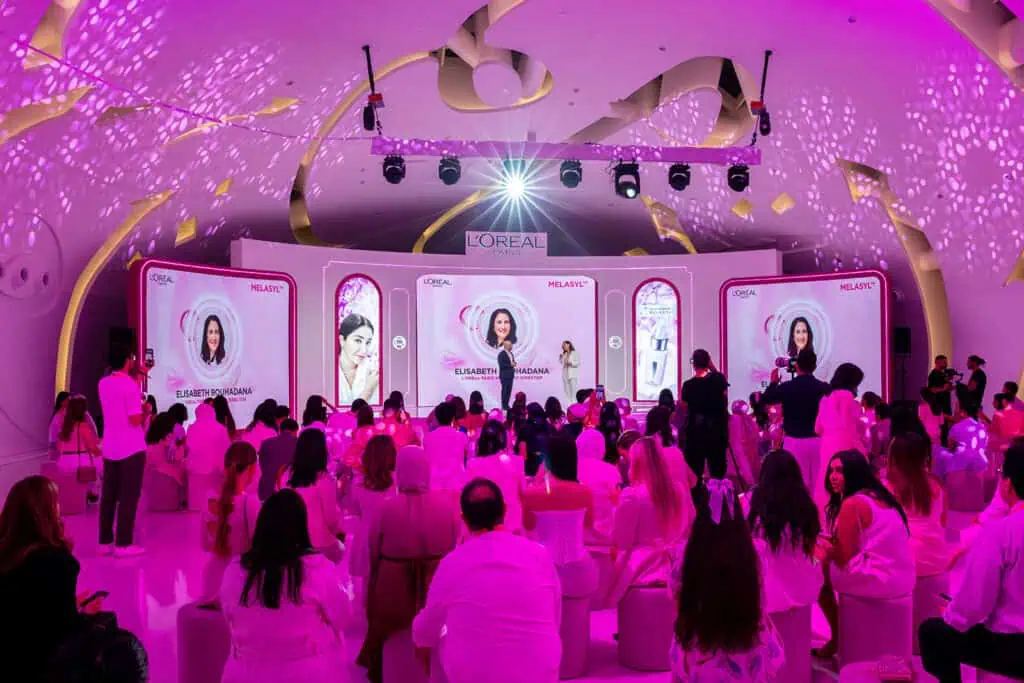 Corporate event with pink lighting and audience in Dubai.