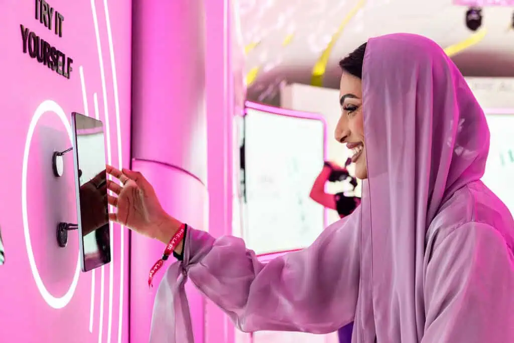 Woman using interactive kiosk at a corporate event in Dubai.