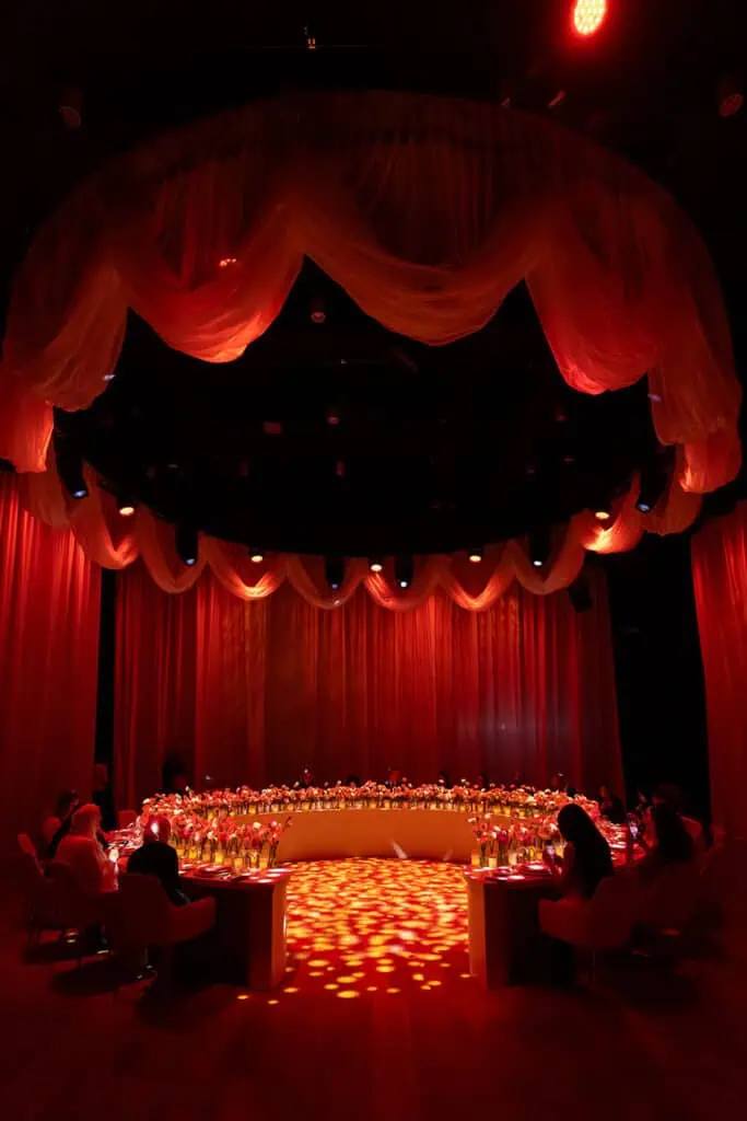 Luxurious event stage with red drapes and lighting in Dubai.
