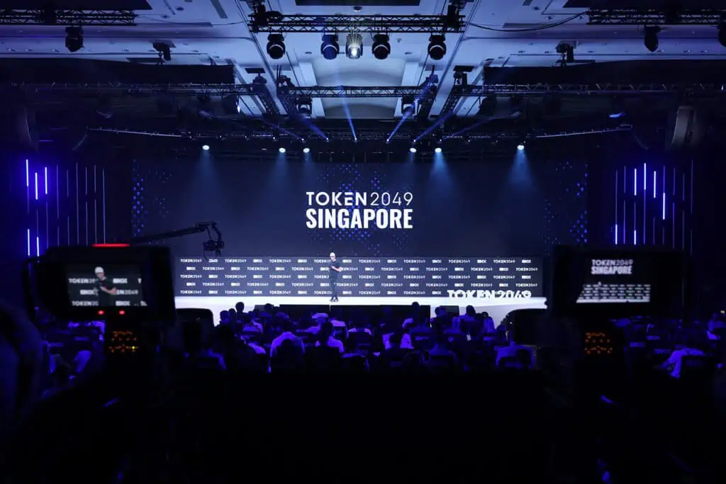 Large conference stage at TOKEN2049 Singapore event with audience and lighting.